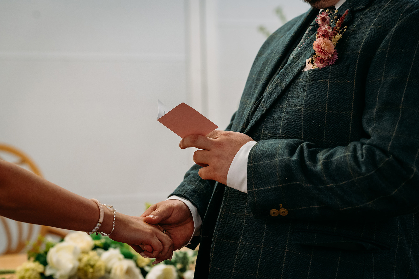 groom holds brides hand and reads vows at Paisley registry office wedding