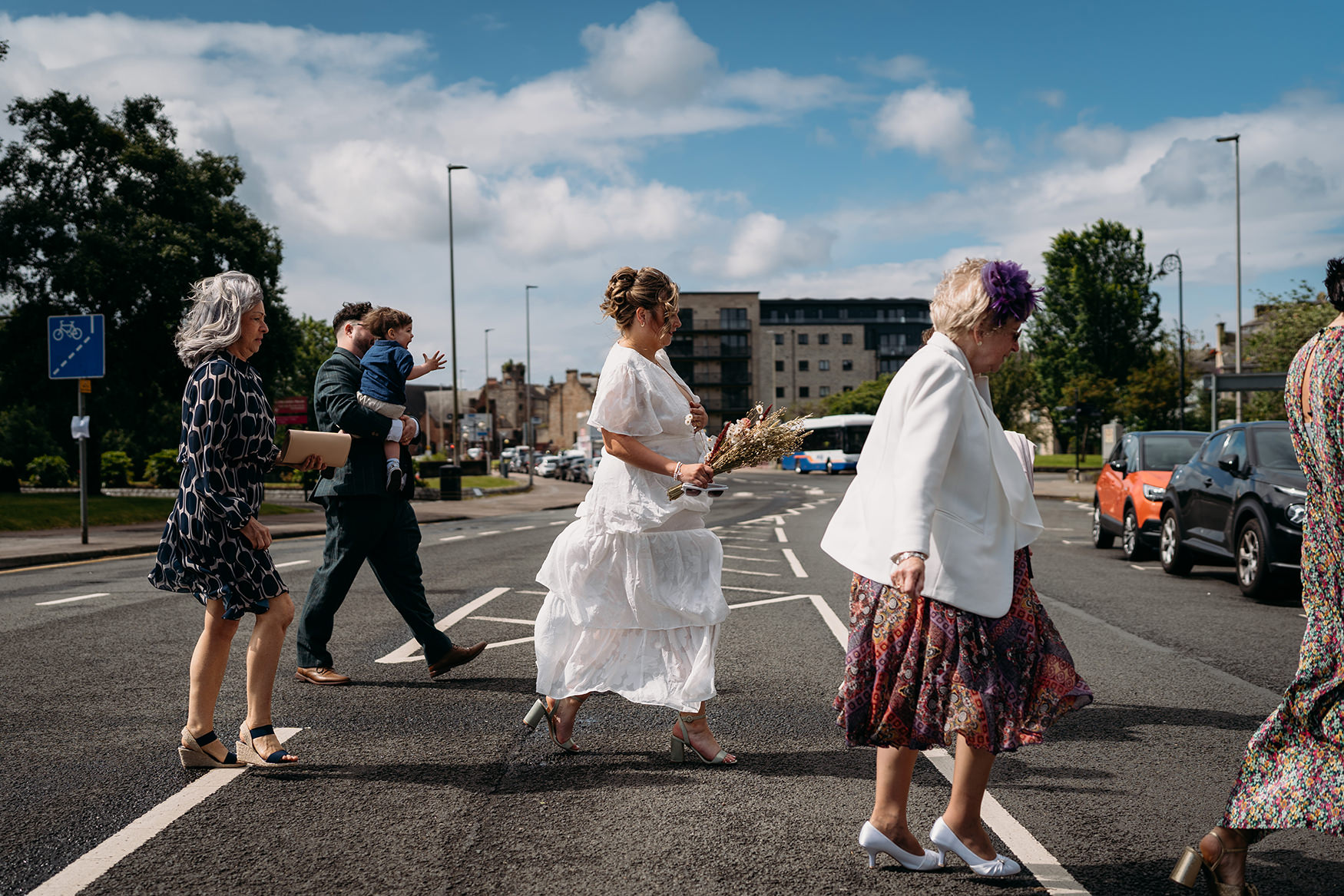 Paisley registry office wedding guests crossing road to Paisley Abbey