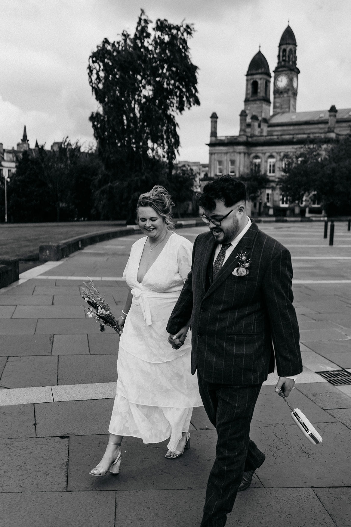 Newlyweds walk past Paisley Town Hall after their Paisley registry office wedding