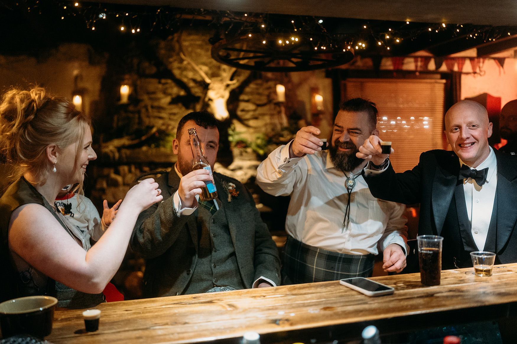 Group of four people cheers at the bar at The Gathering at Woodhead Farm