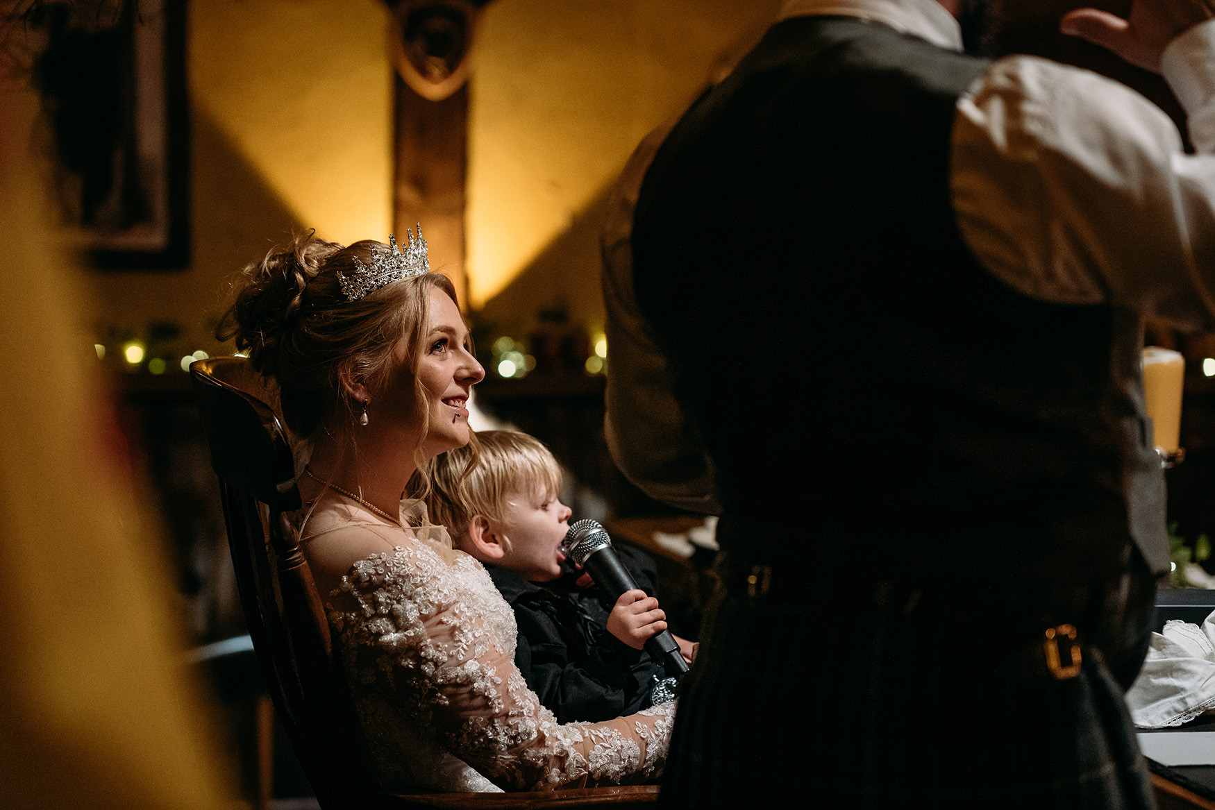 bride looks at groom as he gives his wedding speech at The Gathering at Woodhead Farm 