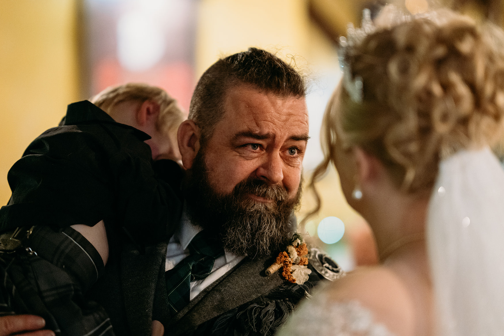 Groom looks at bride during The Gathering at Woodhead Farm wedding ceremony